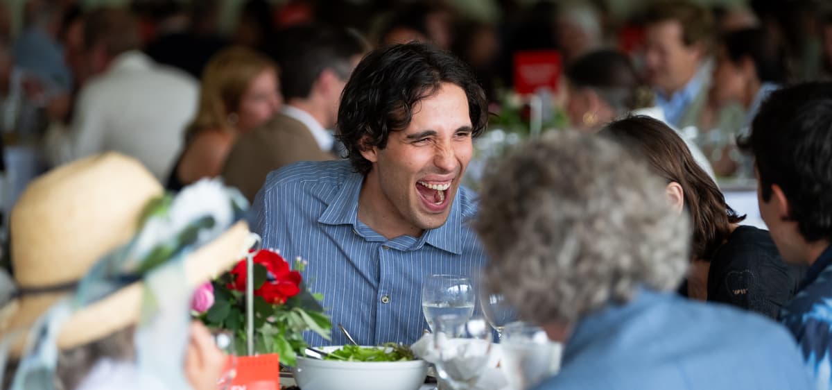 Guest laughing, seated at event table.