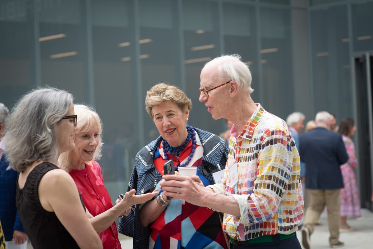 Four individuals including Beth Finch, Ann Beha, Rob Radloff speaking to one another on the terrace of Colby Museum.