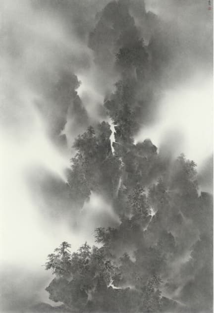 A vertical, monochromatic ink painting in a traditional Chinese style depicts a majestic, misty mountain landscape. Jagged peaks and cliffs emerge from swirling, atmospheric fog, with dark, heavily textured areas suggesting dense forests of pine trees clinging to the slopes, particularly in the lower half and center. The upper portion of the painting is dominated by dark rock forms dissolving into the white mist. The technique uses varying degrees of ink wash, ranging from pale gray to deep black, to create a strong sense of depth, light, and movement of the clouds.