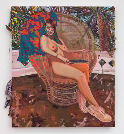 A large-scale, expressive painting of a nude Indigenous woman sitting confidently in a tall wicker "peacock" chair. She has long dark hair and red markings on her face, holding a dark blade across her lap. A blue cloth with bright red hibiscus flowers is draped over the back of the chair. The background features tropical palm fronds and a pinkish sky, while the floor is a messy, dark-brown texture. Small pieces of real jewelry and fabric are attached to the edges of the canvas.