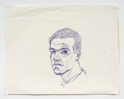 A small, centered ballpoint pen sketch of a man’s head on a rectangular sheet of off-white paper. The portrait is rendered in blue ink with quick, hatching lines used for shading across the man's face and neck.