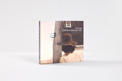 A three-quarter studio shot of the hardcover book By Design: The Worlds of Betsy James Wyeth standing upright against a plain white background.