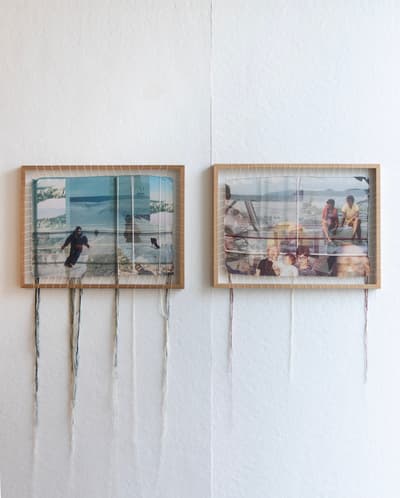 A pair of mixed-media artworks mounted on a white wall. Each piece consists of a light wood frame with white thread strung vertically across it, creating a loom-like structure. Woven through the threads are translucent photographic prints: the left showing a figure skiing in a blue landscape, the right showing a group of people in a domestic setting. Long strands of thread hang freely from the bottom of both frames.