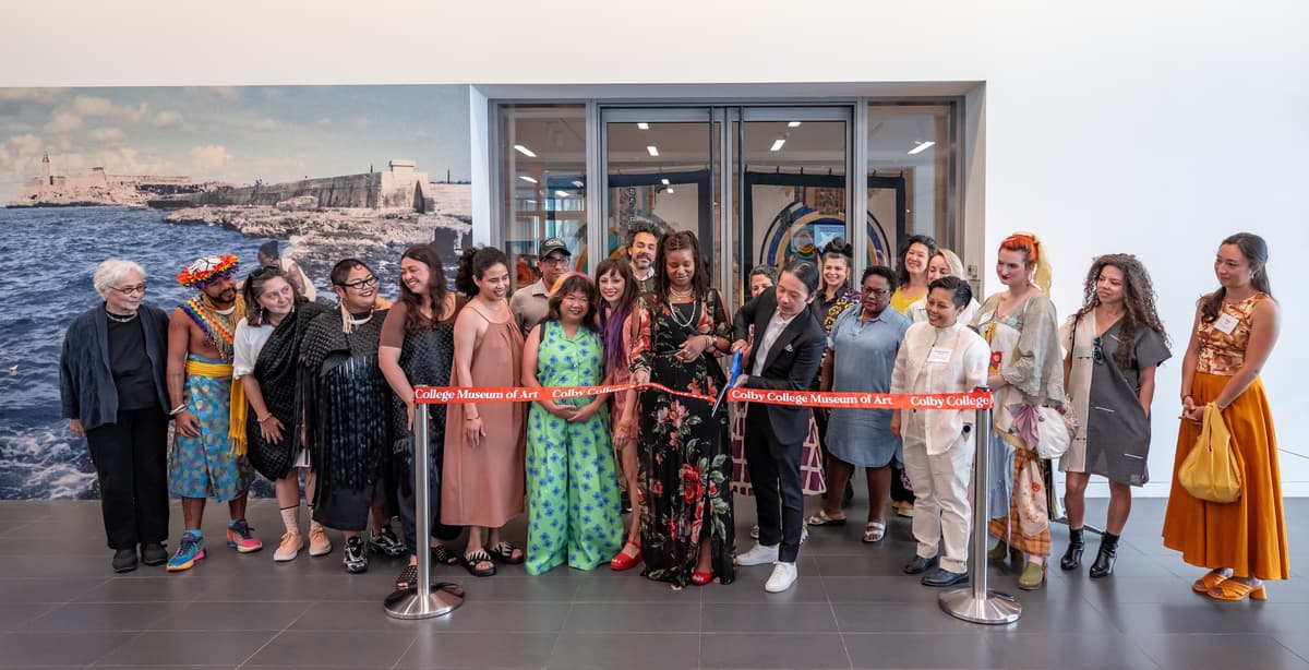 Artists and curators gather to cut a ribbon in front of the doors to the Upper Jetté Gallery, which includes the Imagining Archipelagos exhibition.
