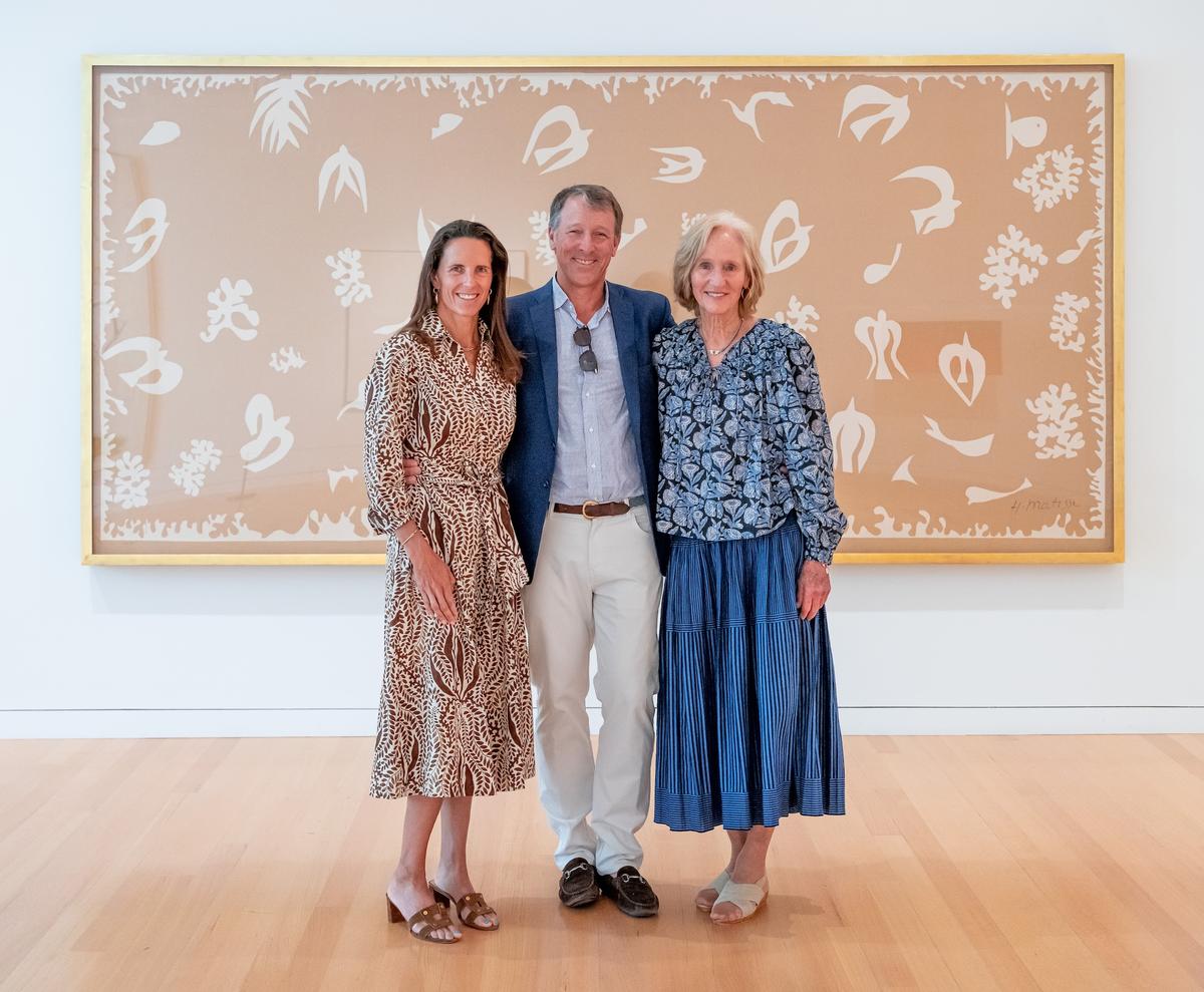 Members of the Eastman family smiling for a photo in front of Henri Matisse's "Océanie, le ciel".