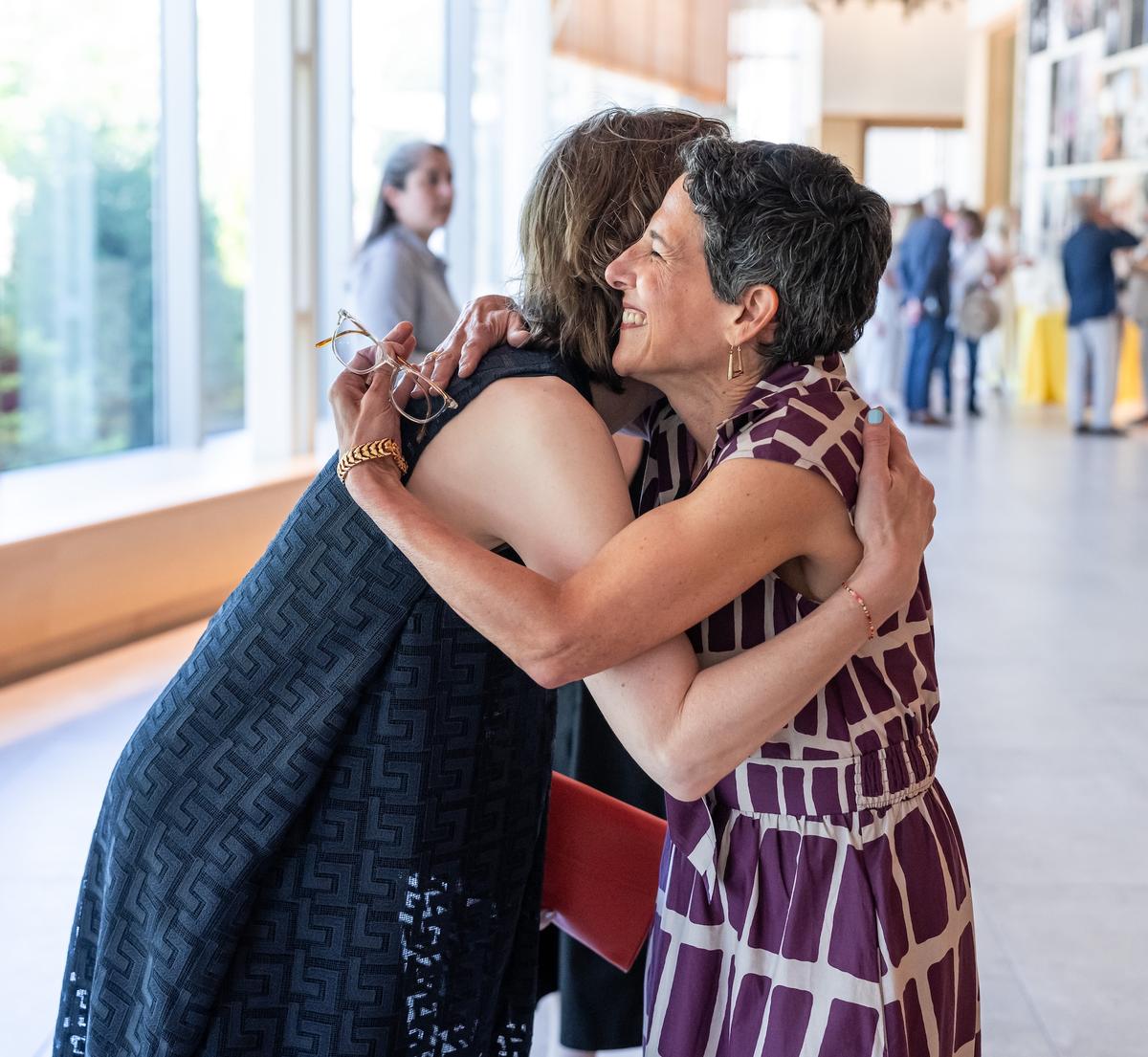 Carolyn Muzzy Director Jacqueline Terrassa embraces former director Sharon Corwin.
