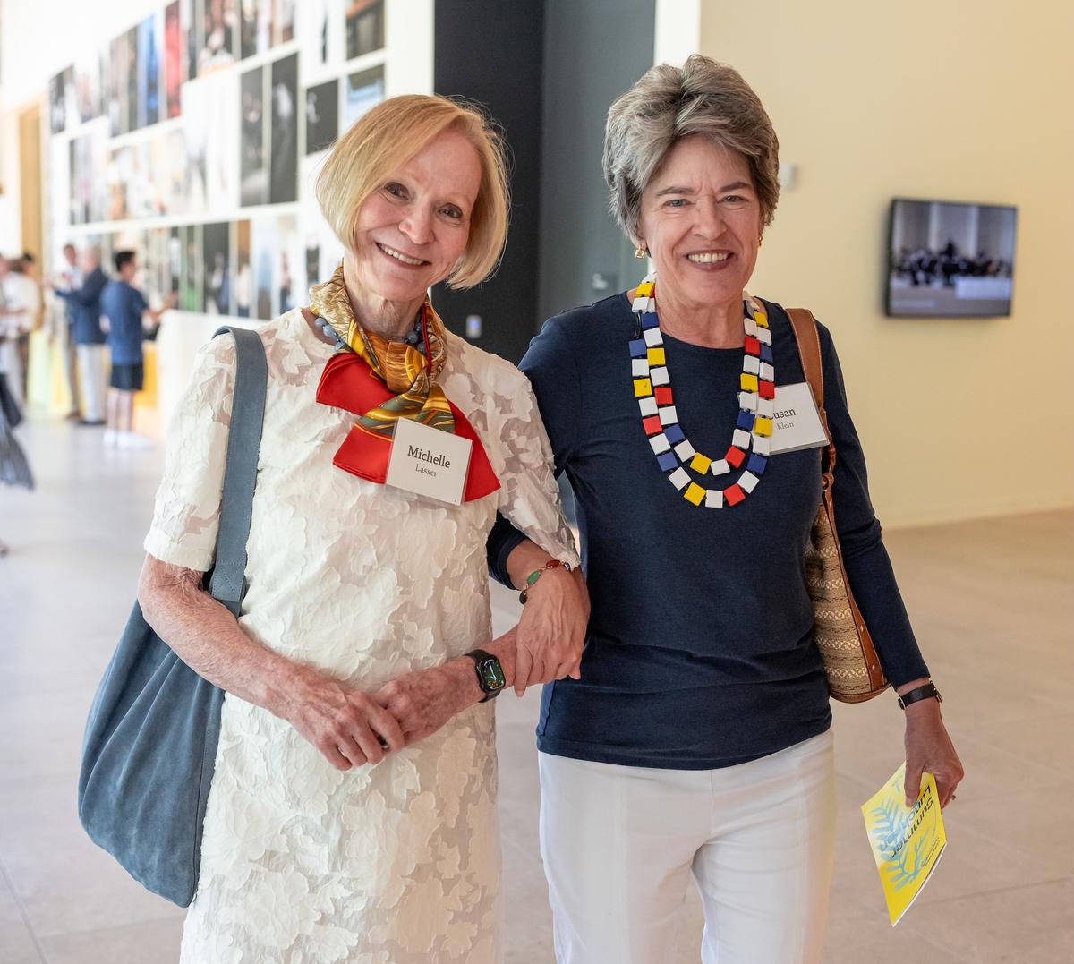Michelle Lasser and Susan Klein smile for a photo as they walk arm in arm.