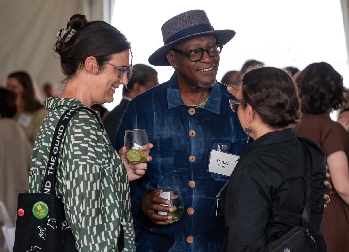 Artist Daniel Minter in conversation with two other guests at the Summer Luncheon.
