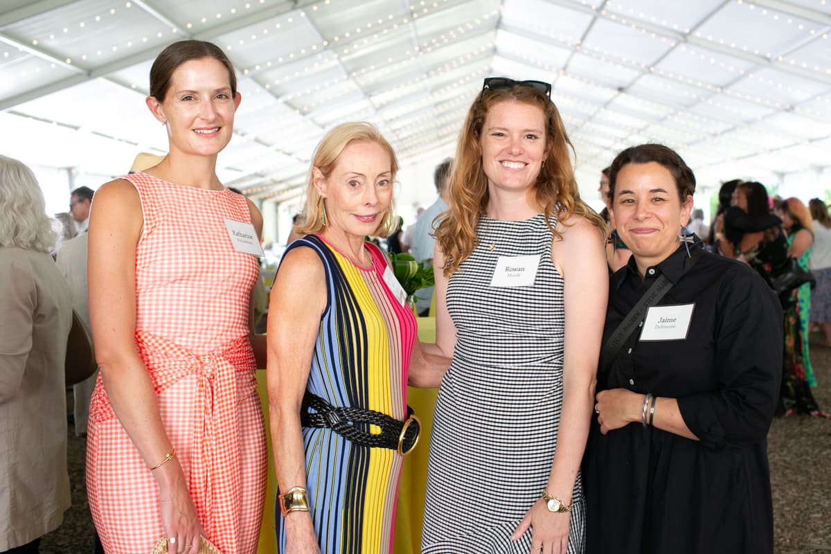 A group of people smile for a photo at the Summer Luncheon.