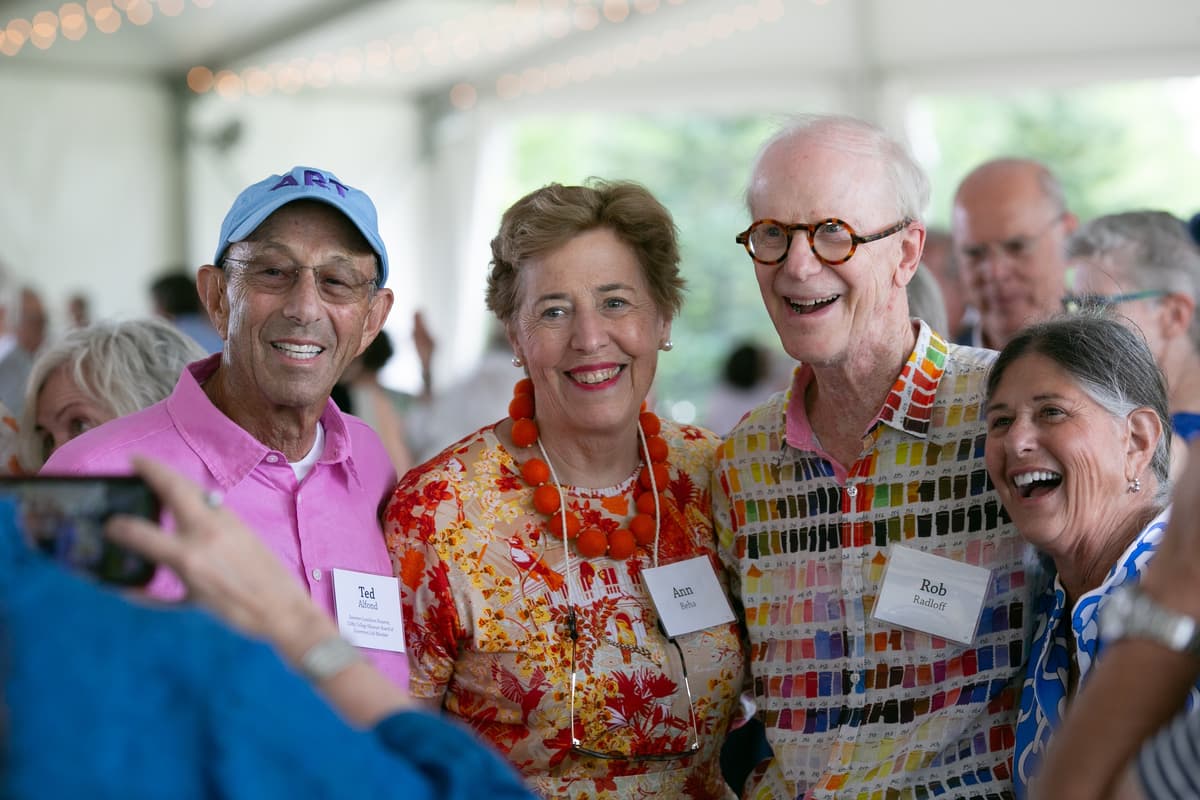 Four people smile for a photo at the Summer Luncheon.