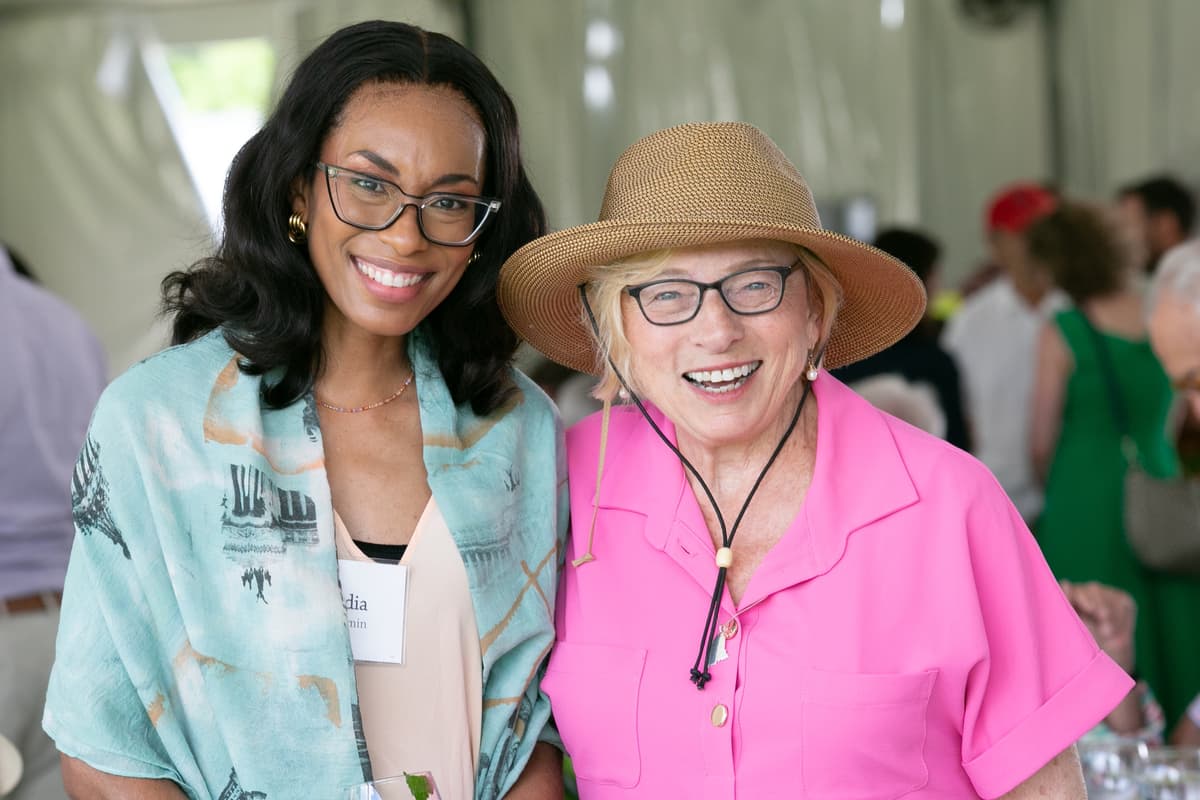 Two people smile for a photo at the Summer Luncheon.