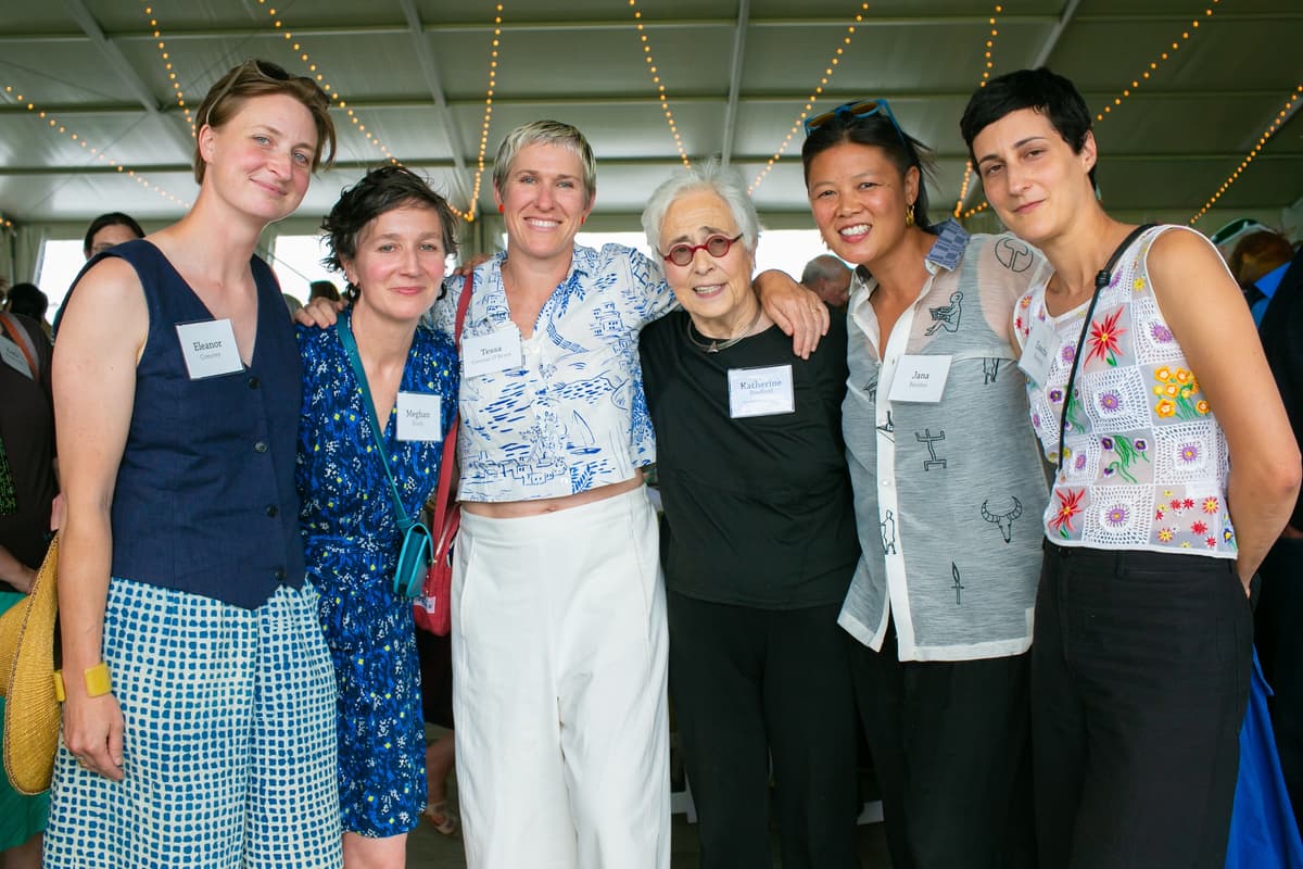 A group of people smile for a photo at the Summer Luncheon.