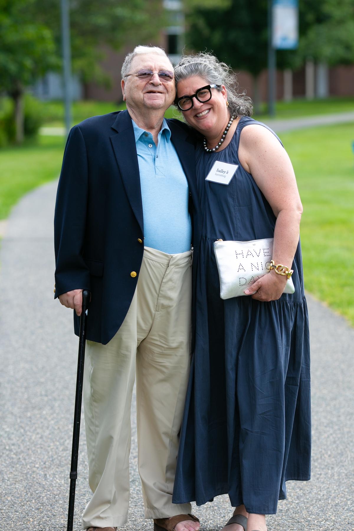 Two people smiling for a photo on a pathwalk.