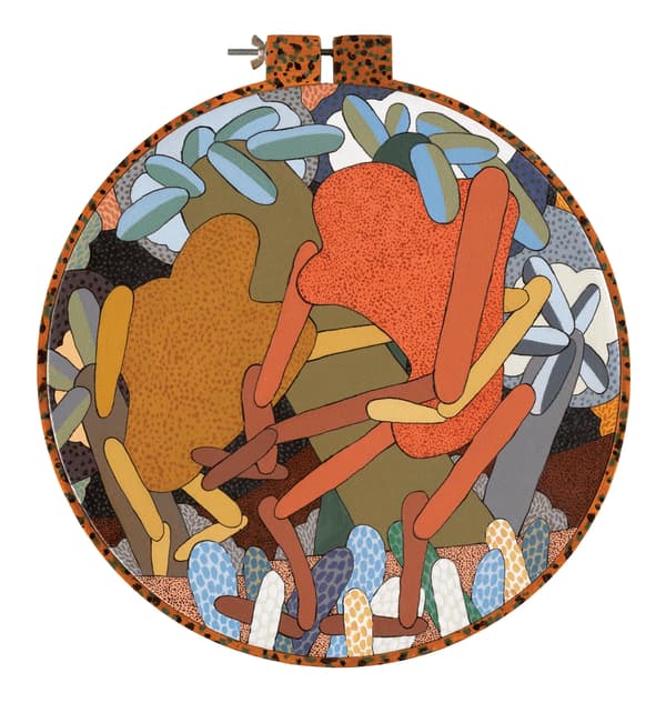 A circular multimedia artwork framed inside a wooden embroidery hoop depicts an abstract, stylized landscape with dense, interlocking organic shapes. Two main orange and ochre figures with finger-like extensions sit in the center, surrounded by pale blue and grey tubular plant forms and a patterned ground texture. The composition uses flat colors, fine stippling, and bold black outlines to separate the interlocking elements.