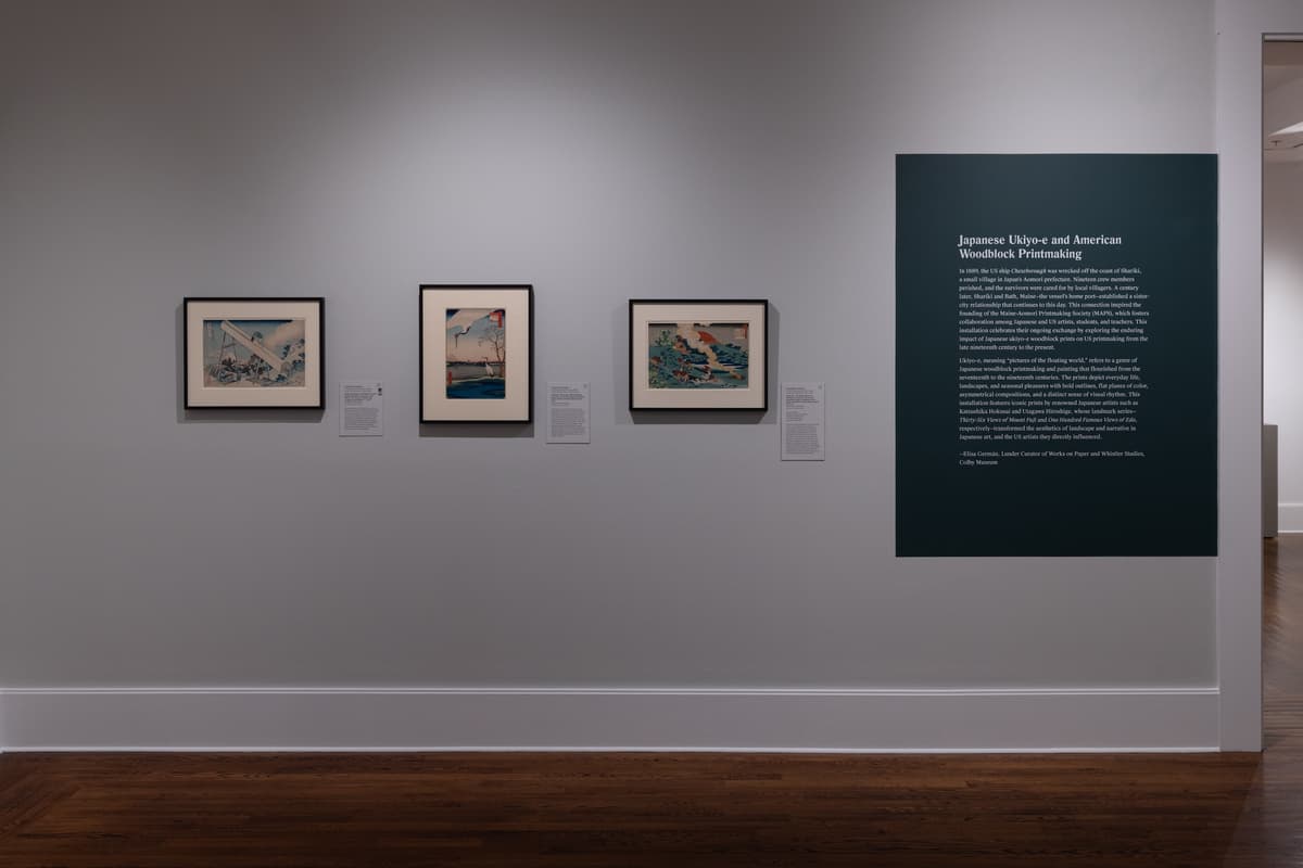 Three framed japanese woodblock prints on a wall, next to a block of wall text on a green background.