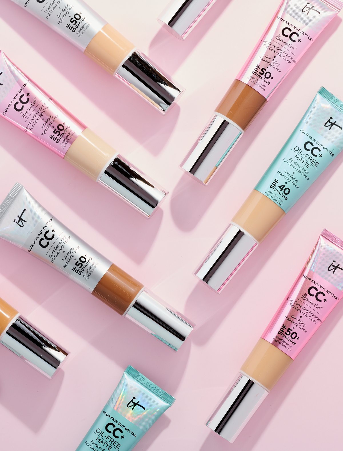 CC cream tubes scattered diagonally across a pale pink ground