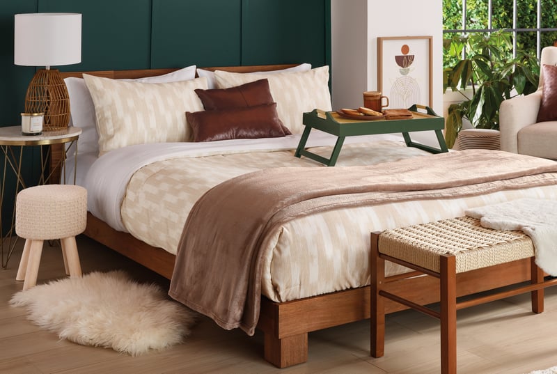 A bedroom with a breakfast tray on the bed, styled against a green panelled wall