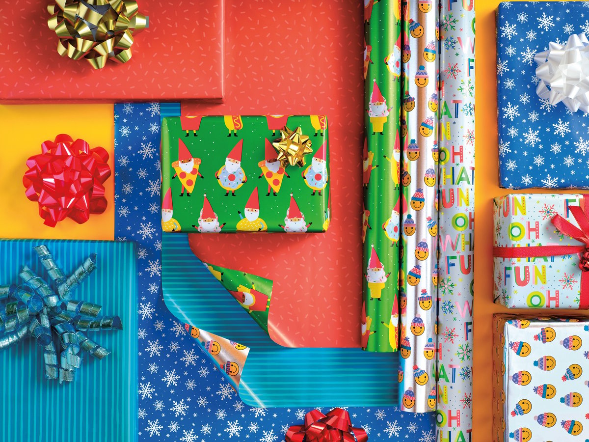 Rolls of Christmas wrapping paper and bows photographed from directly overhead