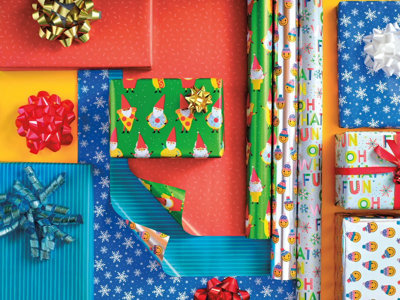 Rolls of Christmas wrapping paper and bows photographed from directly overhead