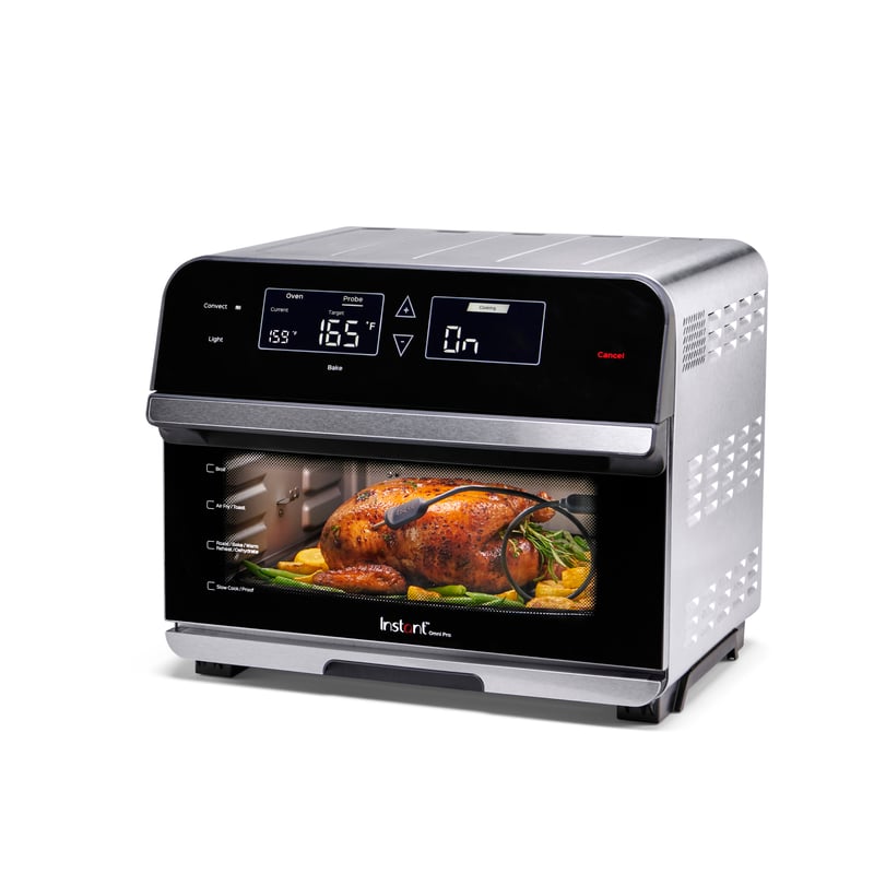 An Instant Pot air fryer oven with a roast chicken inside, photographed on white