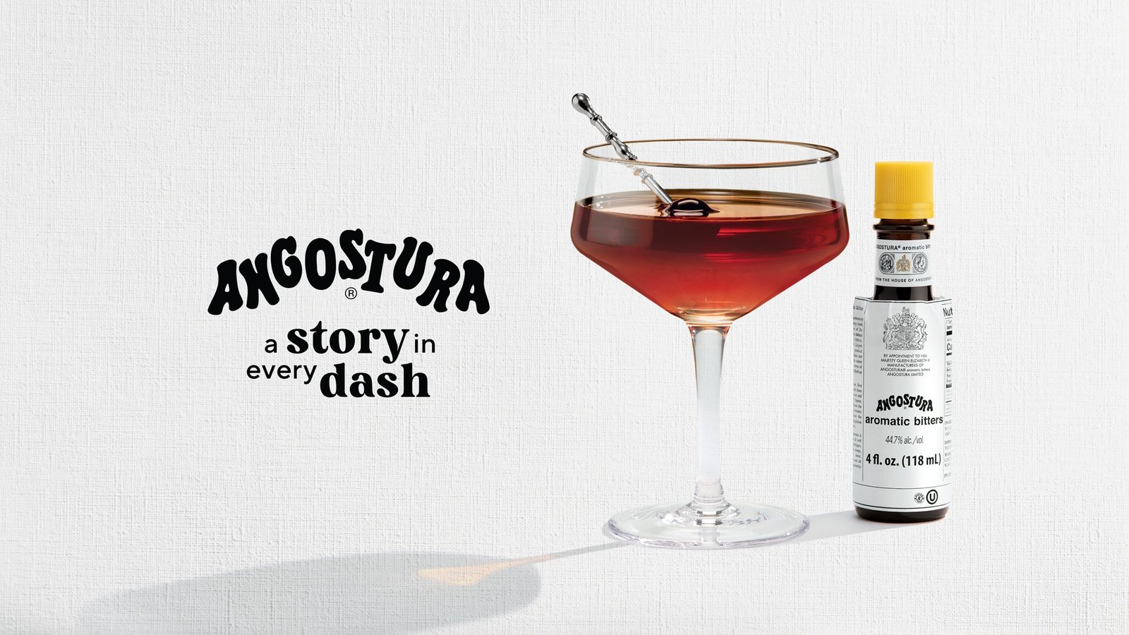 A Manhattan cocktail beside a bottle of Angostura bitters with the line a story in every dash