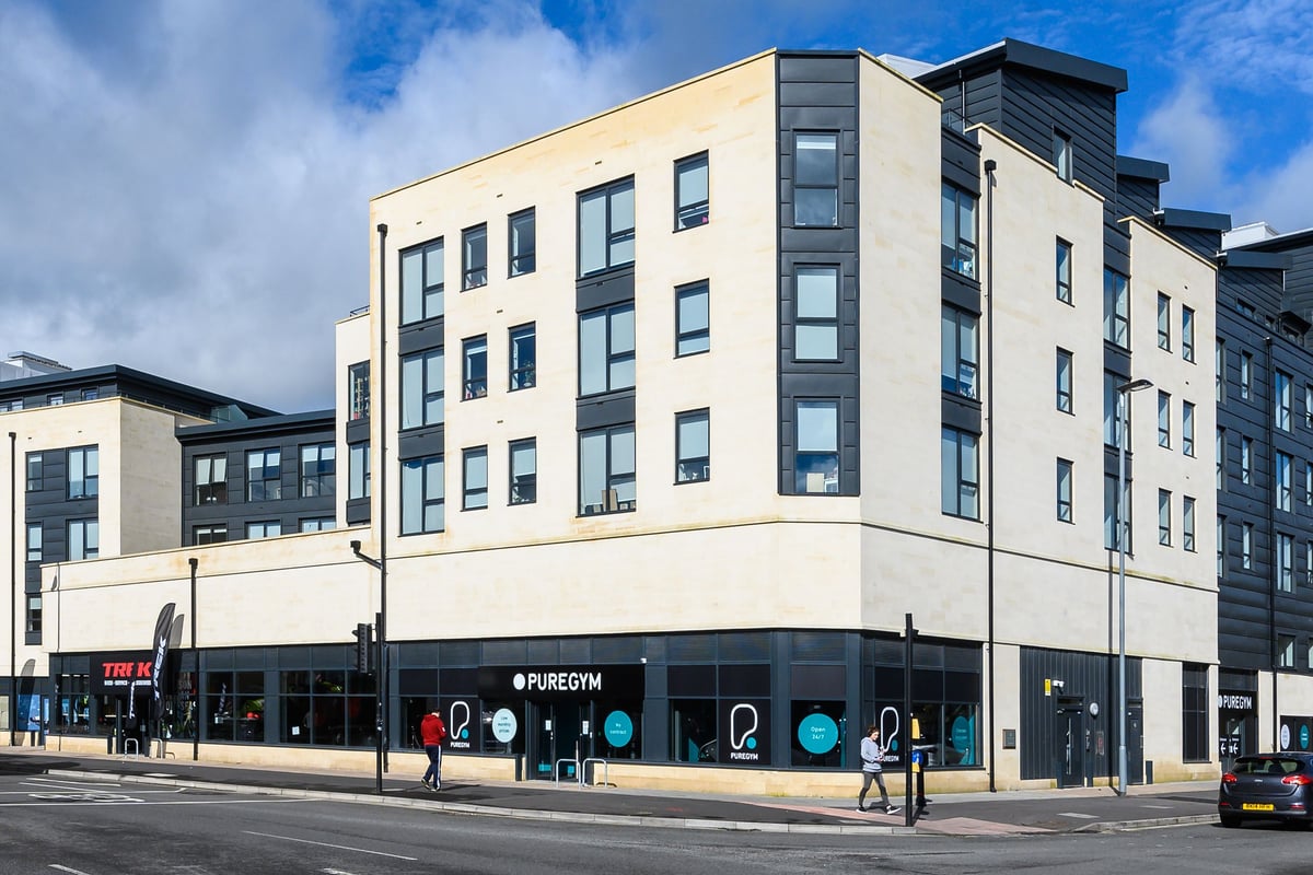 PureGym Bath Spring Wharf: Modern apartment building exterior with gym branded windows below.