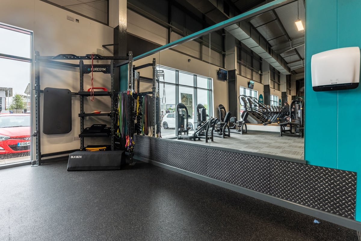 PureGym Widnes: Treadmills, weight racks, resistance machines, rubberised flooring in fitness centre.