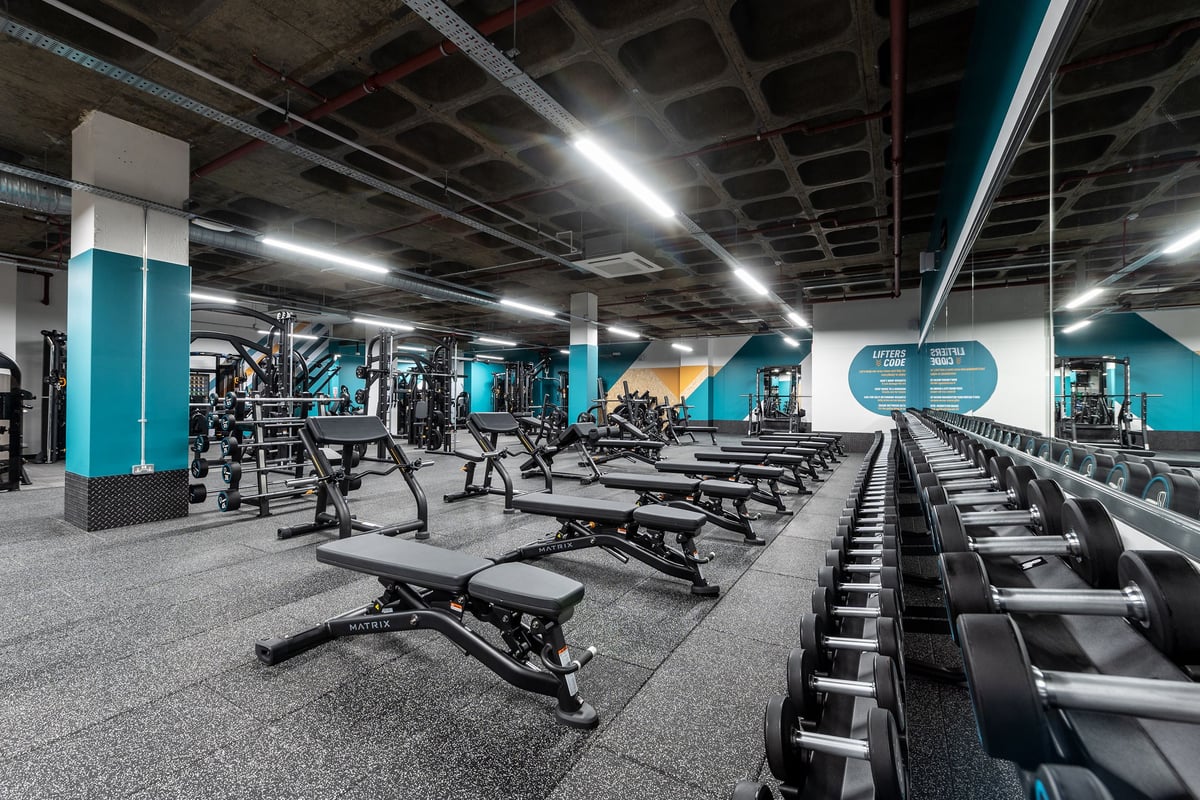 PureGym London Wood Green: Weights racks, benches, treadmills, dumbbells, bright lighting, and turquoise walls.