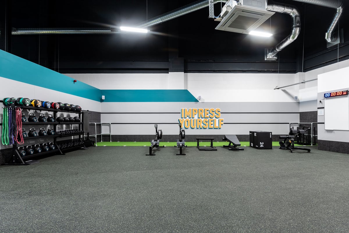 PureGym Stockton-on-tees Teesside Park: Weight racks, free weights, benches, and rubberised flooring in a fitness studio.