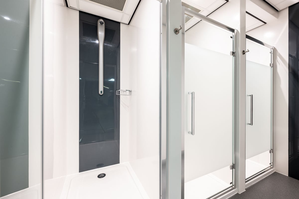 PureGym London Marylebone: Shower cubicles, glass panels, tiled floors - seemingly a changing room area.