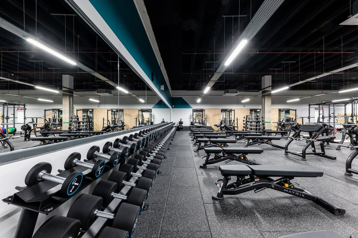 PureGym London Stratford: Rows of resistance machines, free weights, benches, and rubberized flooring in a spacious gym.