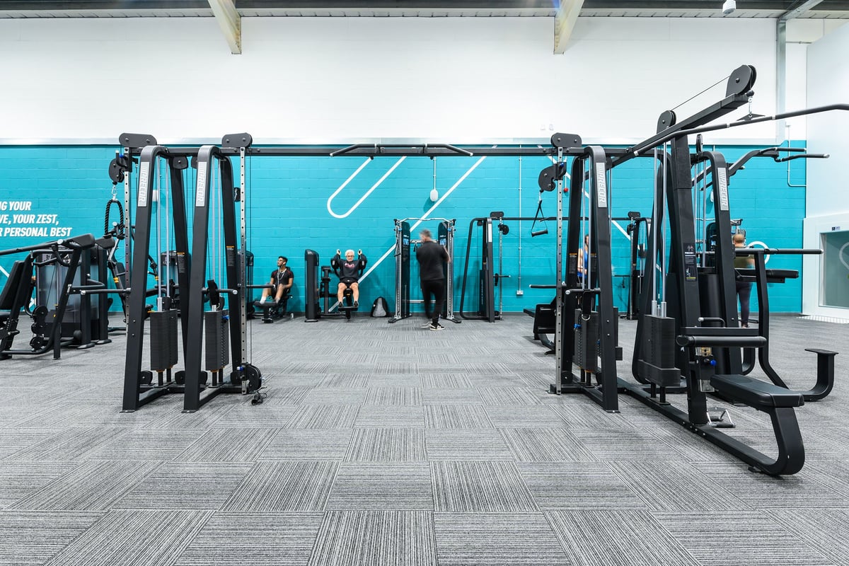 PureGym Burgess Hill: Rows of resistance machines, benches, and weightlifting equipment in a gym studio.