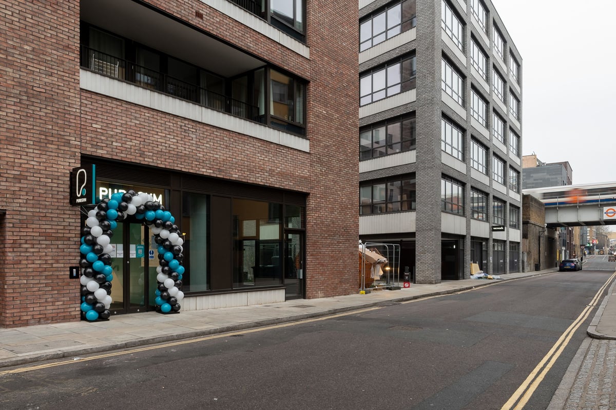 PureGym London Hoxton: Gym entrance with balloon arch decoration and brick building exterior.