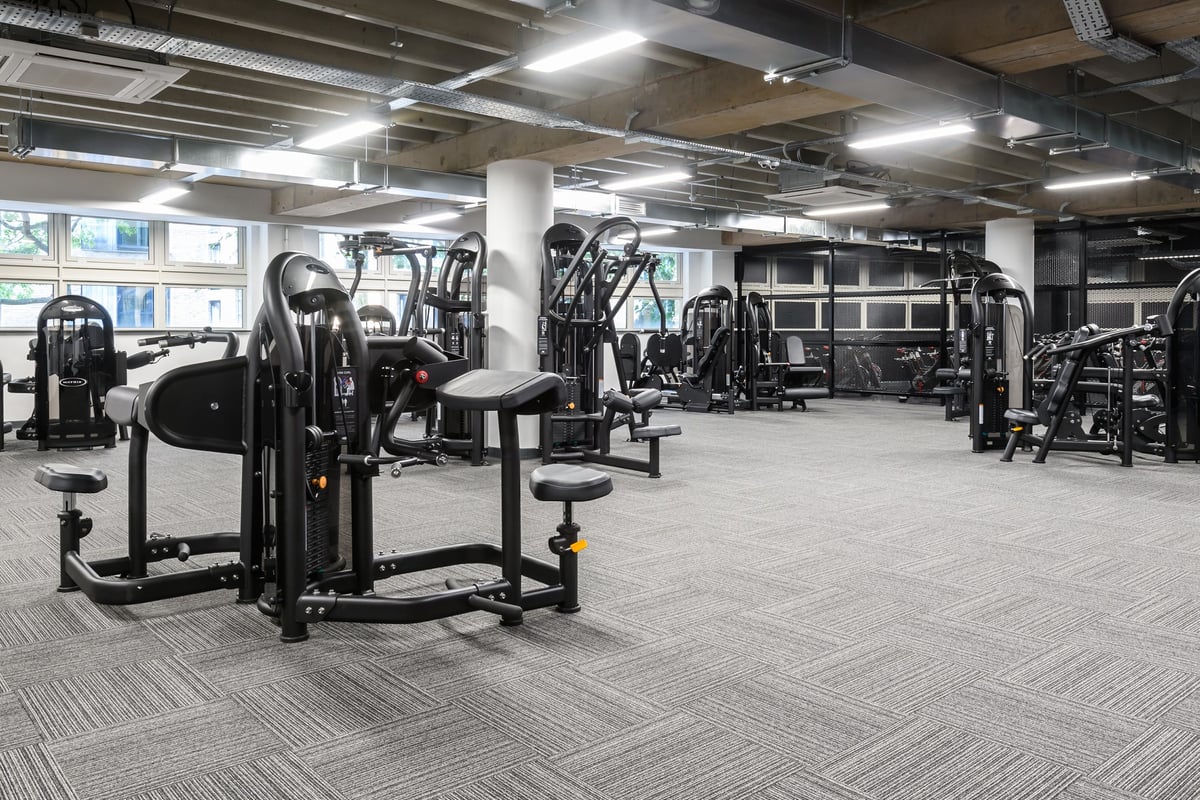PureGym Birmingham Arcadian Centre: Rows of weight machines, benches, and rubberized flooring in a bright, open gym space.