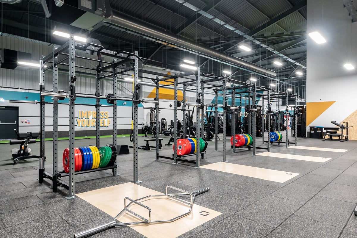 PureGym Sheffield Meadowhall Retail Park: Racks with weight plates in various colours, benches, and rubberized gym floor.