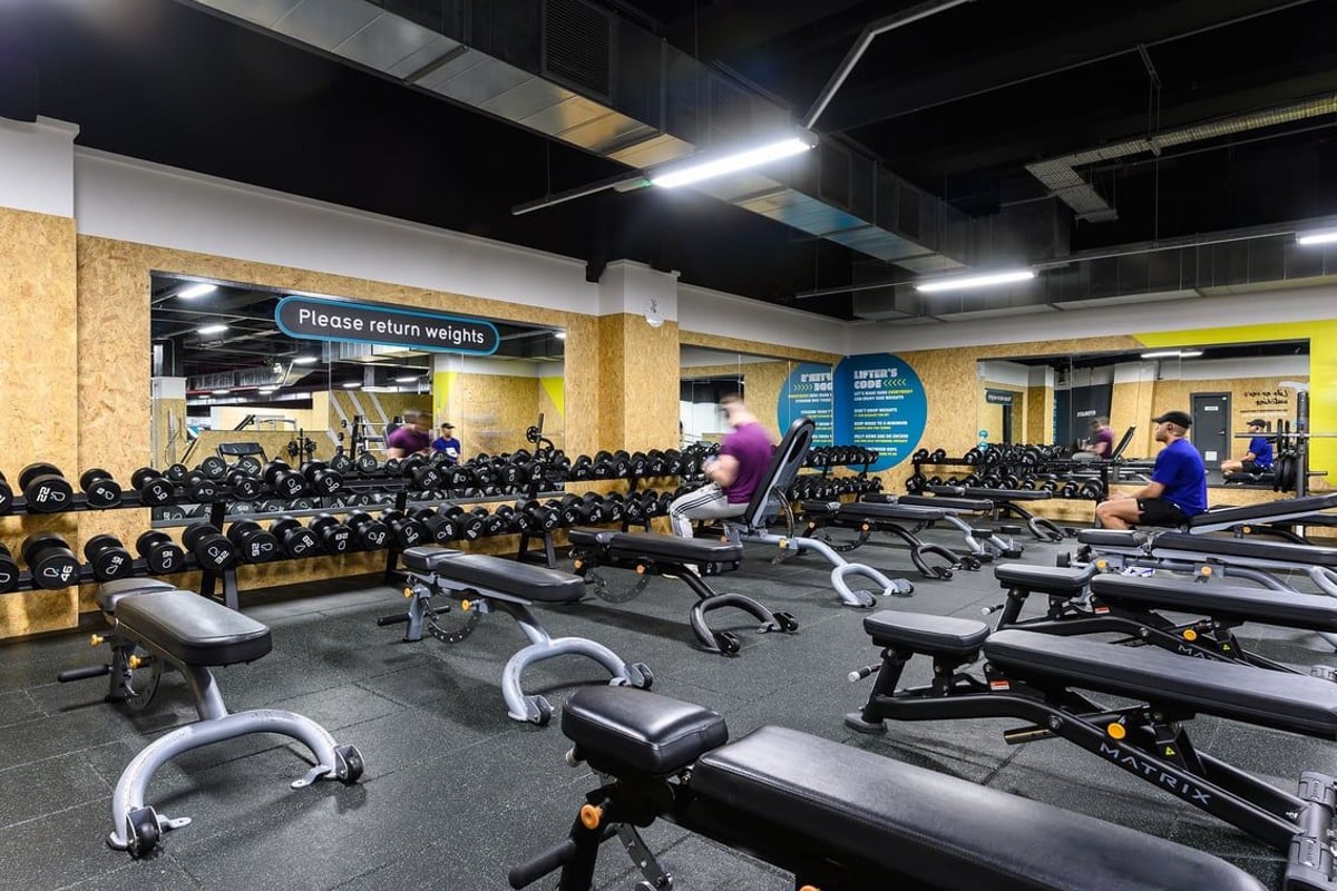 PureGym Leeds City Centre North: Rows of weight benches, free weights galore, signage requesting equipment return.