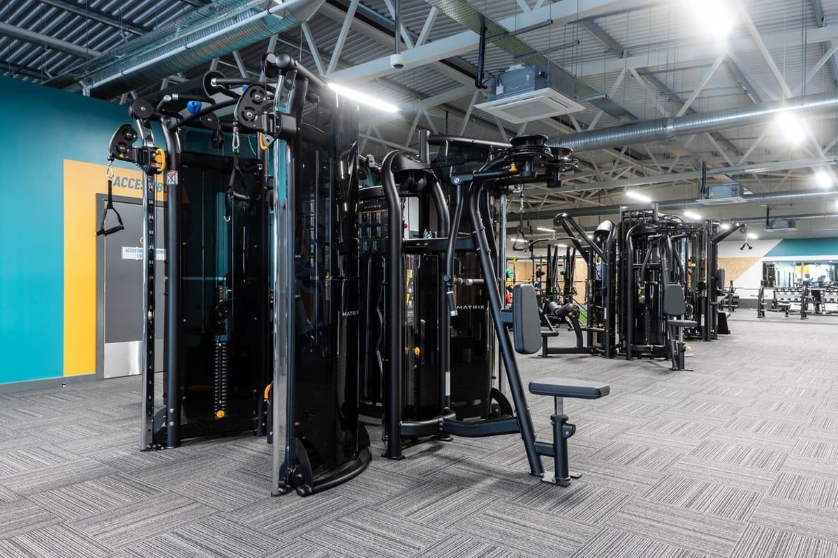 PureGym Barnsley: Rows of strength training machines, cable crossover stations, and weight benches in a brightly lit gym.