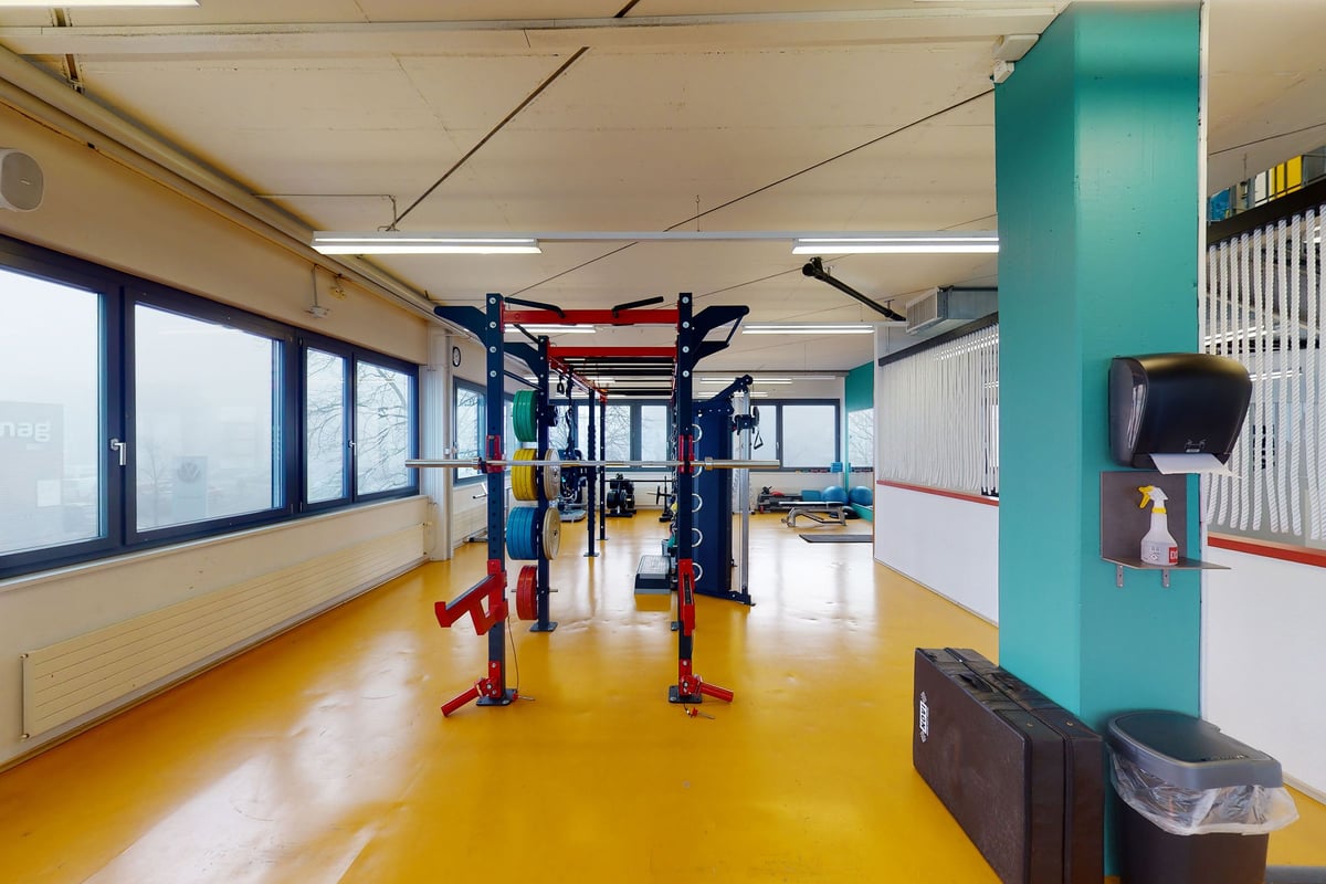 PureGym Uster: Studio de sport avec une structure colorée semblable à une aire de jeux, un sol rembourré et de grandes fenêtres le long d'un mur.