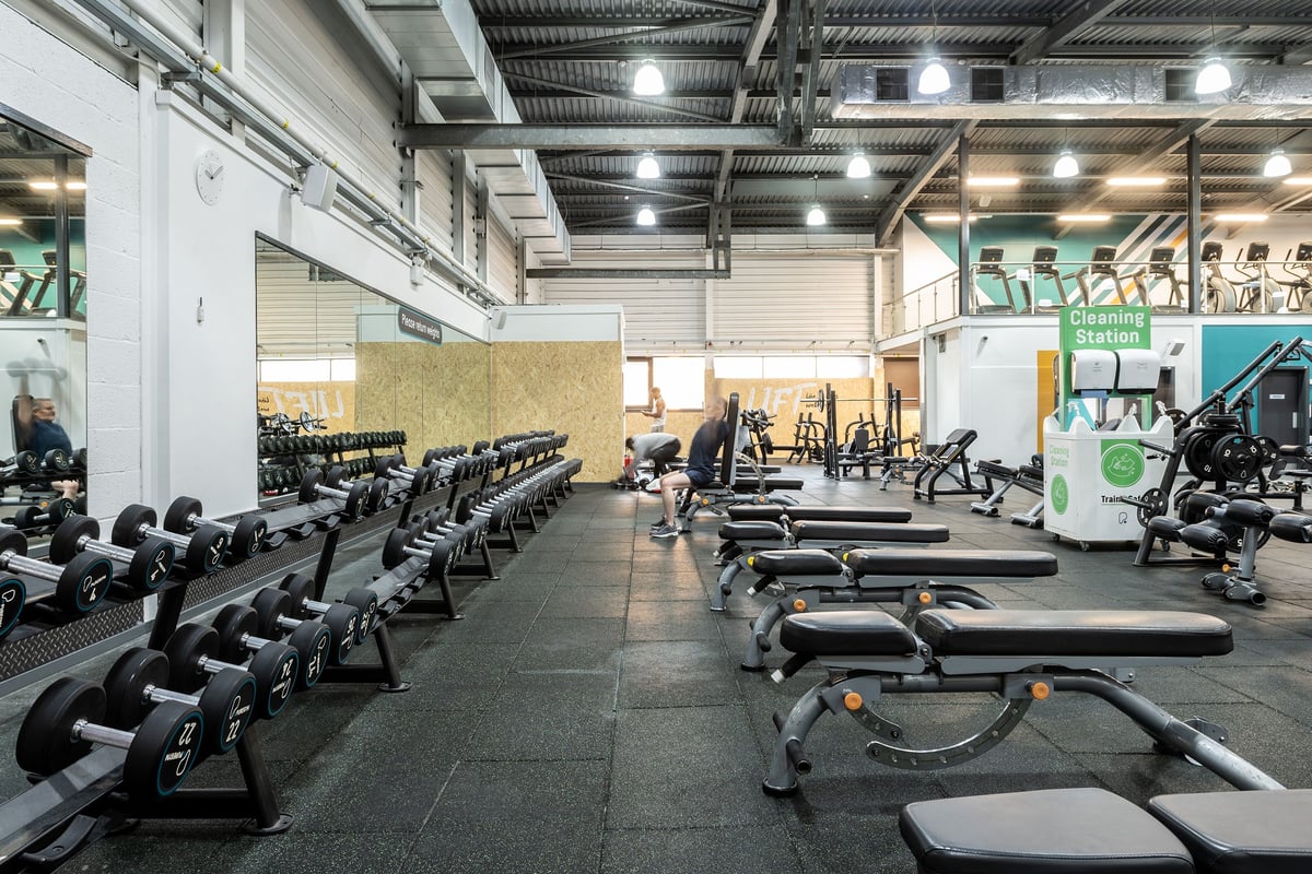PureGym Milton Keynes Winterhill: Rows of treadmills, weight benches, and free weights inside a brightly lit fitness center.