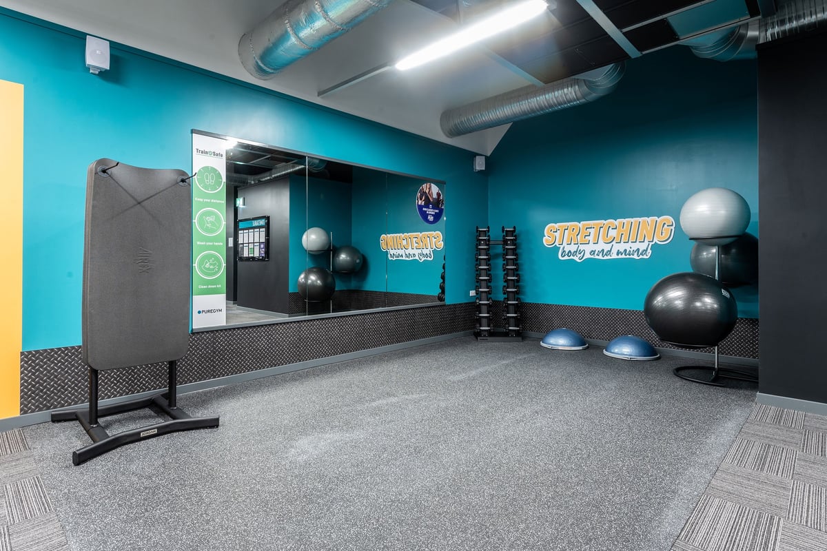 PureGym Torquay Bridge Retail Park: Stretching and stability area with exercise balls, resistance bands, and mirrors.