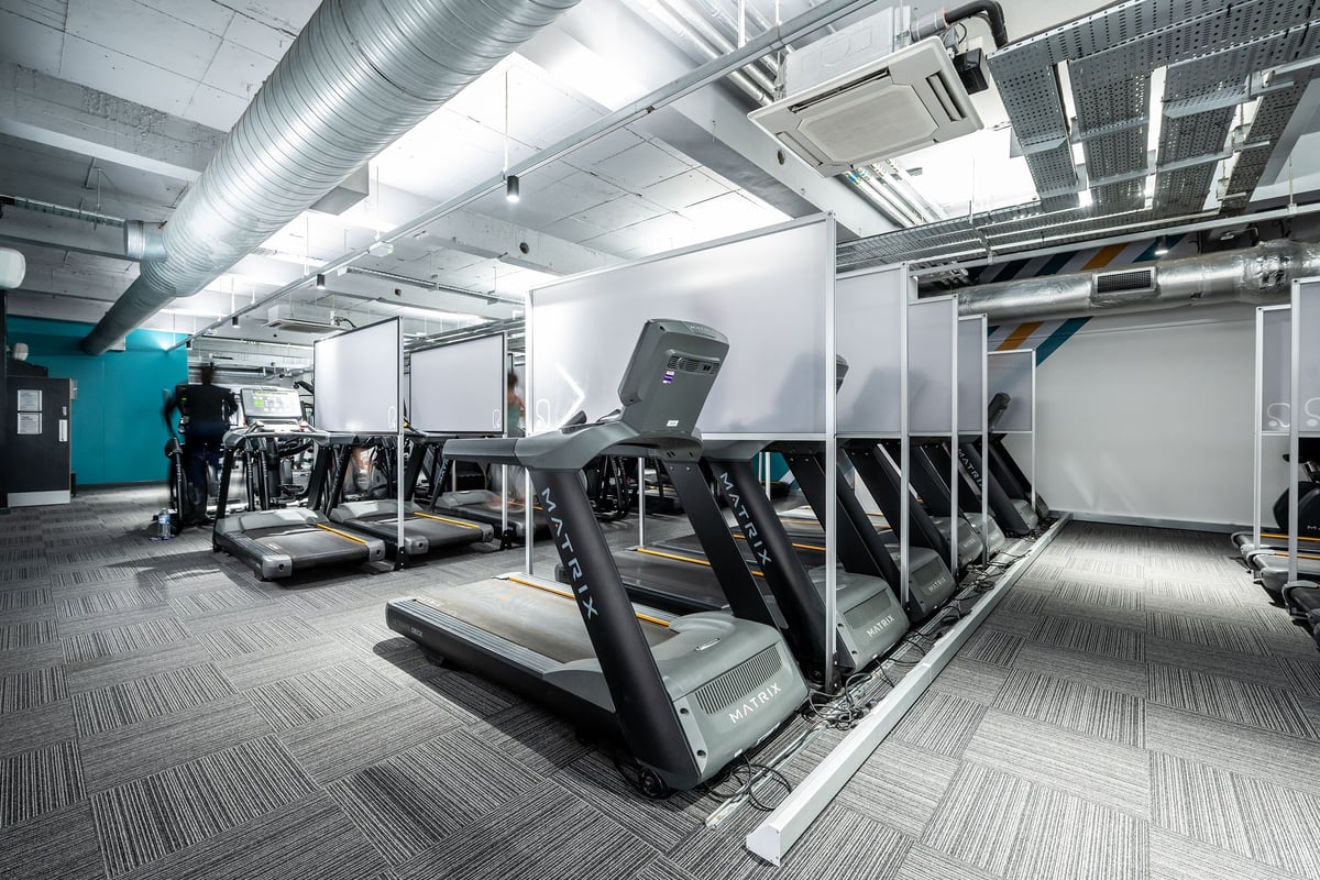 PureGym London Sydenham: Rows of treadmills, weight benches, and resistance machines in a sleek gym interior.