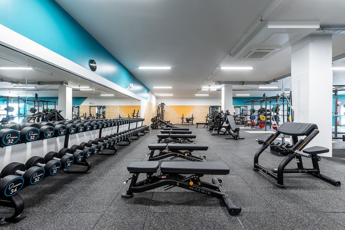 PureGym Coalville: Gym floor with weight machines, free weights, benches, and rubberized flooring.