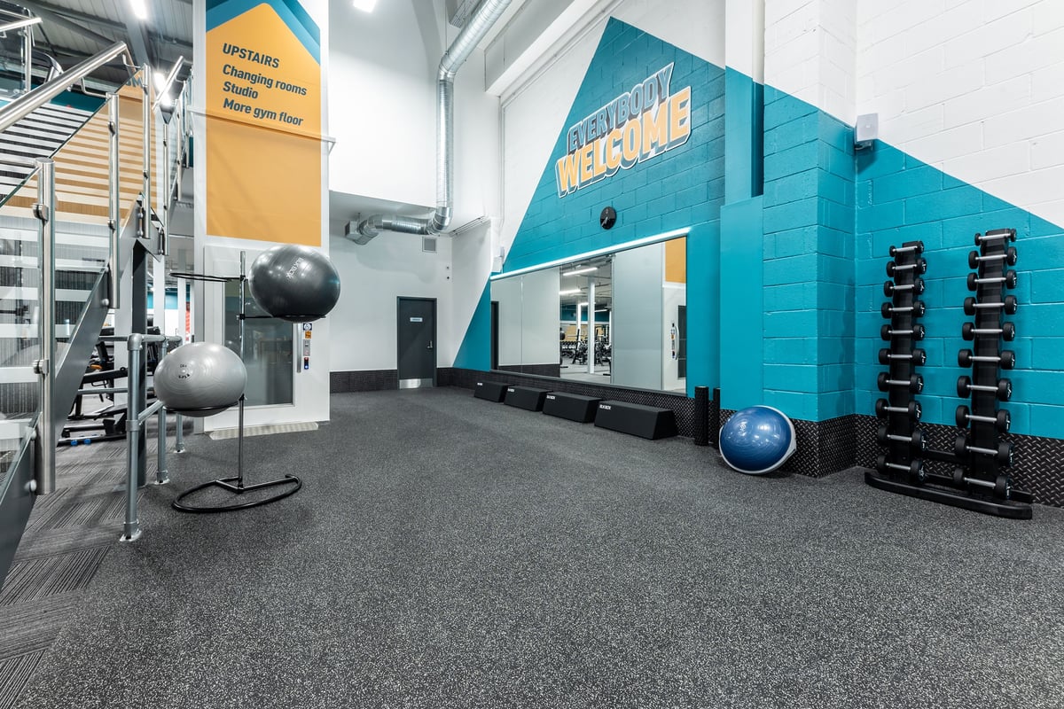 PureGym Watford Waterfields Retail Park: Weight balls, resistance machines, rubberized flooring, teal exercise studio.