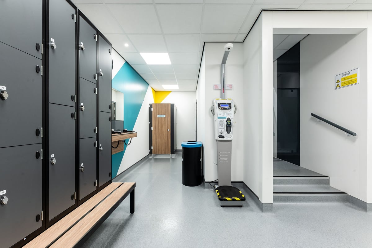 PureGym Durham City Retail Park: Lockers, benches, and cleaning equipment along a corridor.
