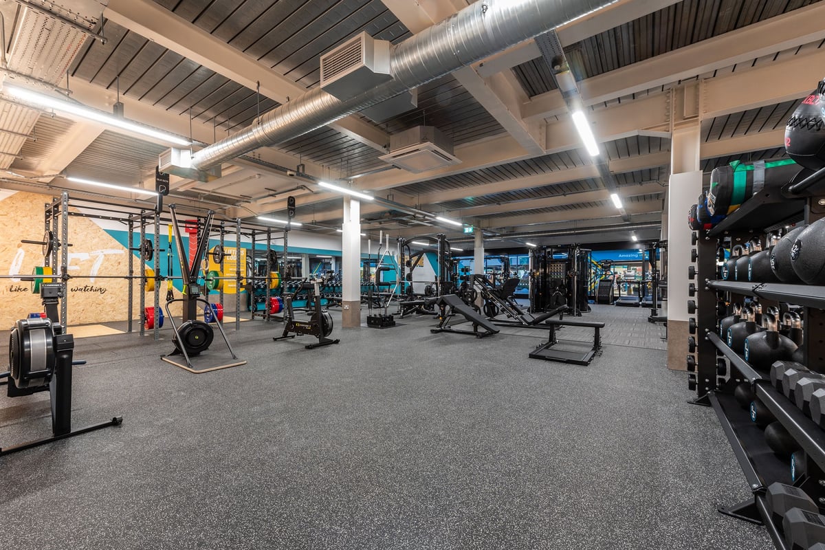 PureGym Droitwich Spa: Weight racks, cable machines, free weights, rubberised flooring in a basement gym.
