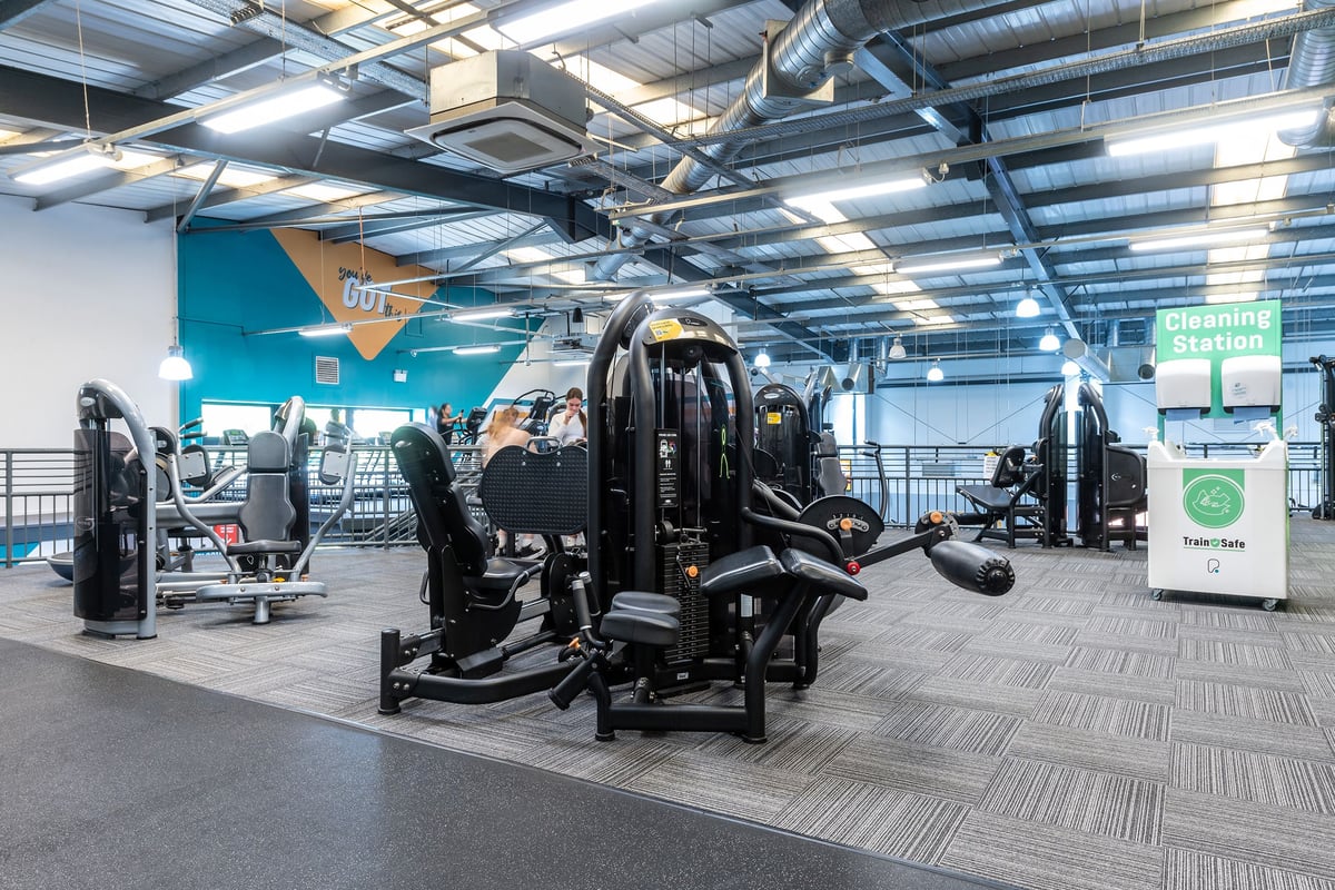 PureGym Aintree: Futuristic training area with resistance machines, free weights, and rubberized flooring.