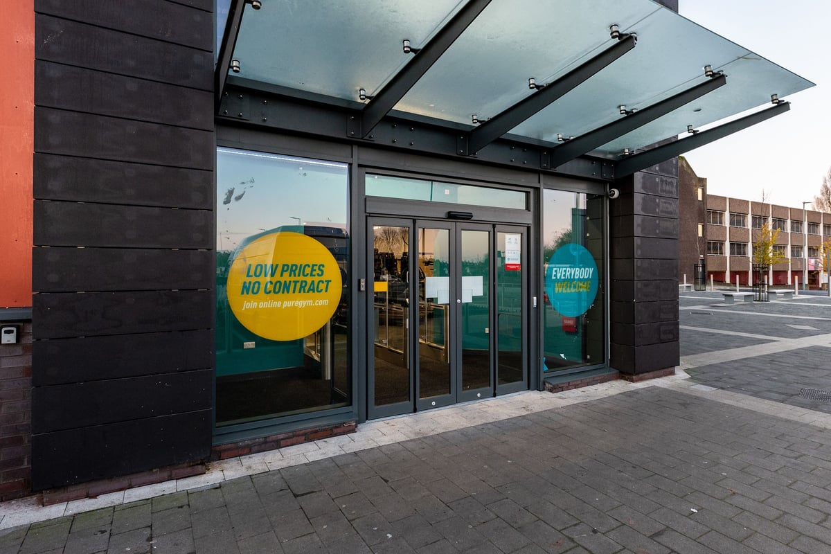 PureGym Kirkby: Low prices no gimmicks storefront with entrance and colourful signage.