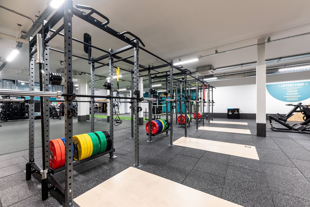 PureGym Redditch Ringway: Squat racks, weight plates in multiple colours, barbells, rubberized flooring, and mirrored walls.