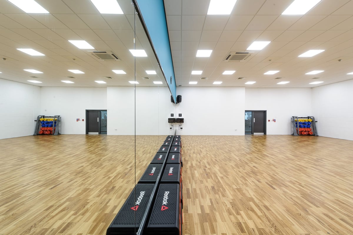 PureGym Worcester: Gym studio with treadmills, mirrored wall, hardwood flooring.