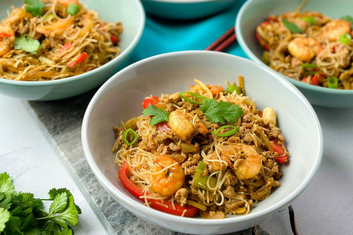 Three bowls of stir-fried noodles with prawns, vegetables and minced meat
